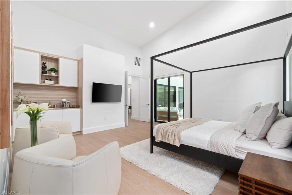 13865 Collier Boulevard Naples, FL 34119 - Photo 26 of 50 Bedroom featuring access to outside, a towering ceiling, light hardwood / wood-style flooring, and multiple windows