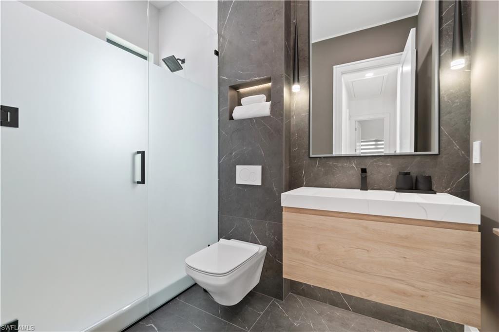 13865 Collier Boulevard Naples, FL 34119 - Photo 36 of 50 Bathroom with tile patterned flooring, a shower with shower door, dual vanity, and toilet