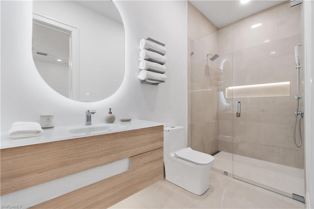 13865 Collier Boulevard Naples, FL 34119 - Photo 38 of 50 Bathroom with tile patterned floors, toilet, and a tile shower