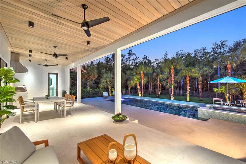 13865 Collier Boulevard Naples, FL 34119 - Photo 43 of 50 Pool at dusk featuring an in ground hot tub and a patio