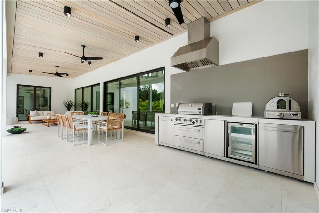 13865 Collier Boulevard Naples, FL 34119 - Photo 46 of 50 130 sq. ft. laundry and walk-in pantry with Whirlpool appliances, ductless dryer, and built-in fridge