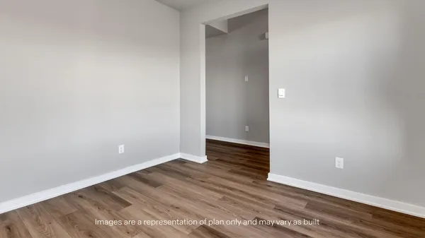 a view of an empty room with wooden floor and closet