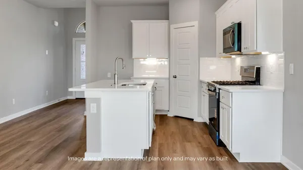 a kitchen with a sink a stove and cabinets