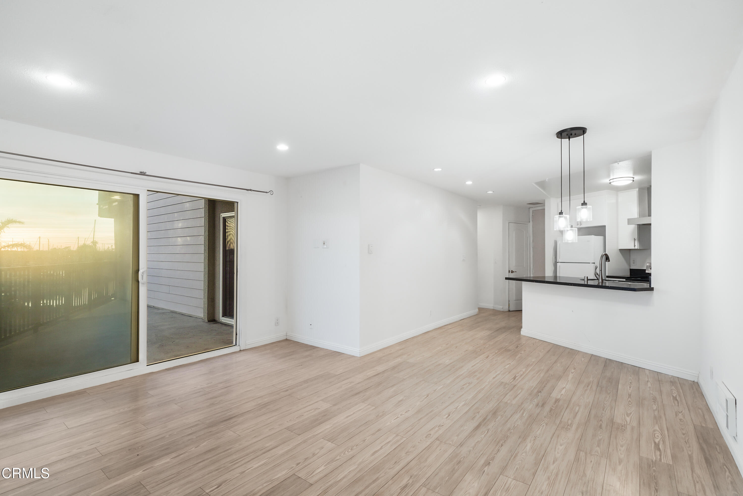 3101 Peninsula Road, Unit 107 Oxnard, CA 93035 - Photo 8 of 24 a view of an empty room with wooden floor and a window