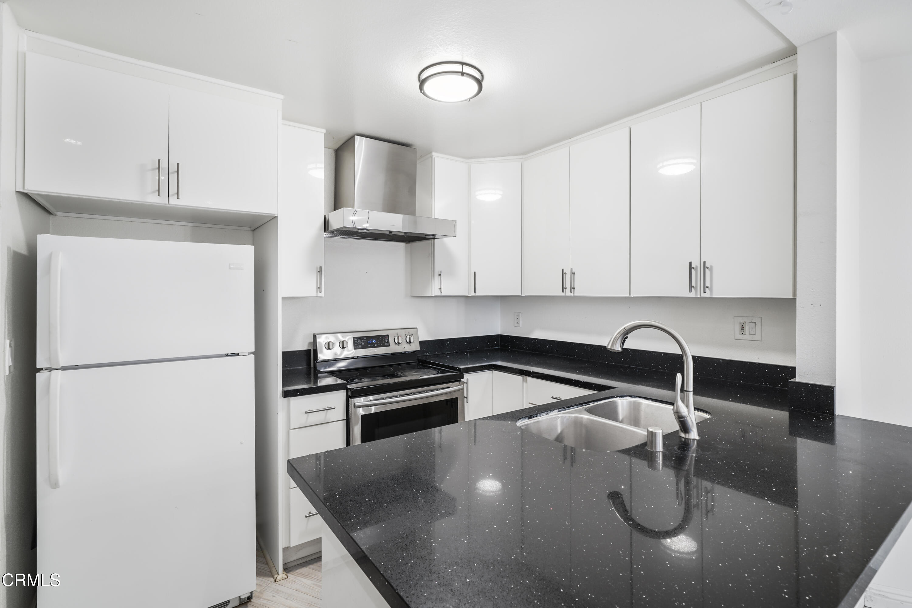 3101 Peninsula Road, Unit 107 Oxnard, CA 93035 - Photo 9 of 24 a kitchen with stainless steel appliances granite countertop a sink a stove and a refrigerator
