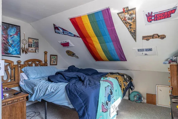 a bedroom with a bed and a painting on the wall