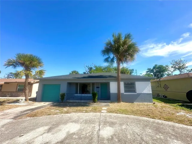 a view of a house with a patio and a yard
