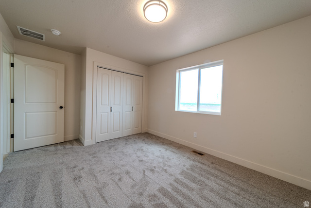 130 Pole Line Road, Unit 2 Roosevelt, UT 84066 - Photo 22 of 33 Neutral-toned room featuring light beige walls and grey patterned carpet flooring