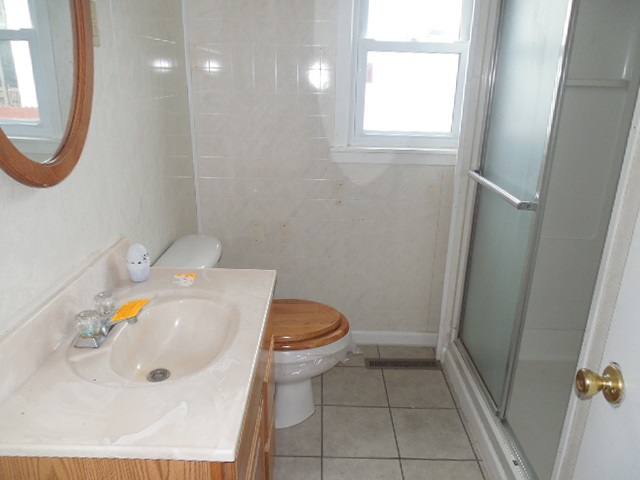 5925 Island Road Harvard, IL 60033 - Photo 14 of 22 a bathroom with a sink a toilet and a mirror