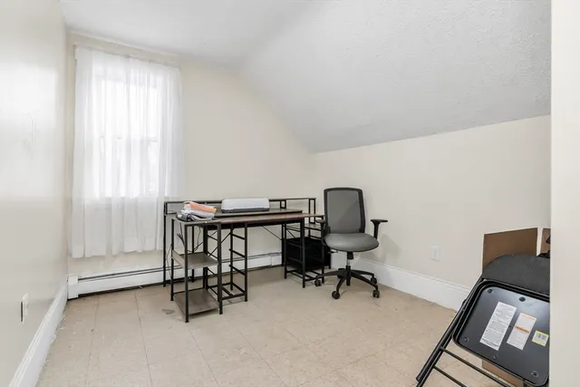 a view of a workspace with furniture and a window