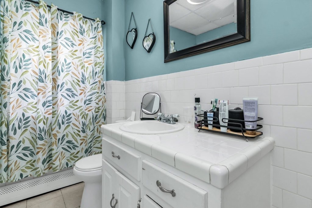 70 Butler Street Lawrence, MA 01841 - Photo 7 of 19 a bathroom with a sink toilet and mirror