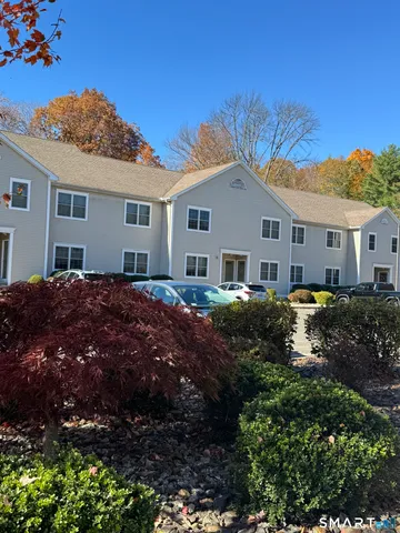 a view of house with a big yard and potted plants