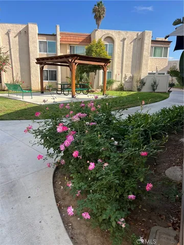a view of a house with a big yard and flower plants
