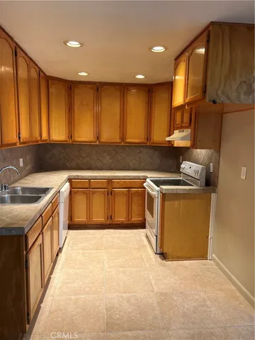 a kitchen with stainless steel appliances granite countertop a sink a stove and a refrigerator