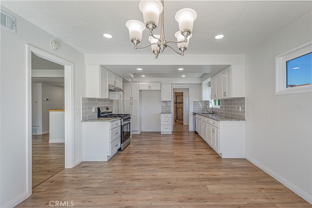 1480 East Colver Place Covina, CA 91724 - Photo 15 of 31 a large kitchen with kitchen island a refrigerator a stove a sink dishwasher with a dining table and chairs