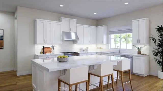 a kitchen with a sink a stove cabinets and wooden floor