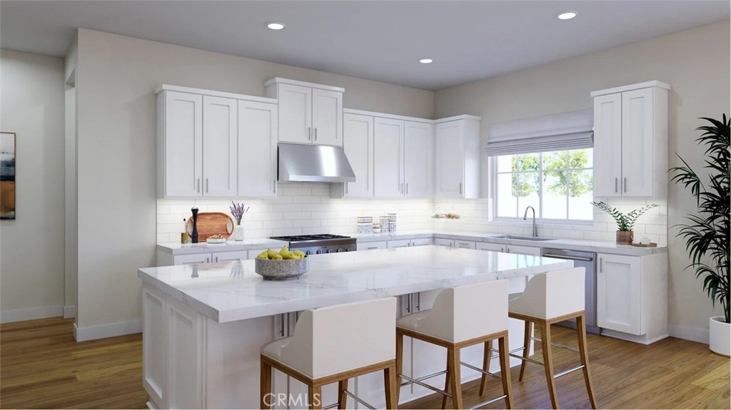 a kitchen with a sink a stove cabinets and wooden floor