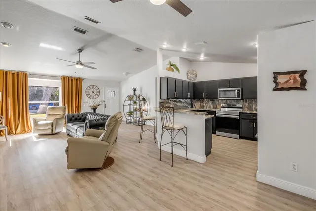 a living room with furniture and kitchen view