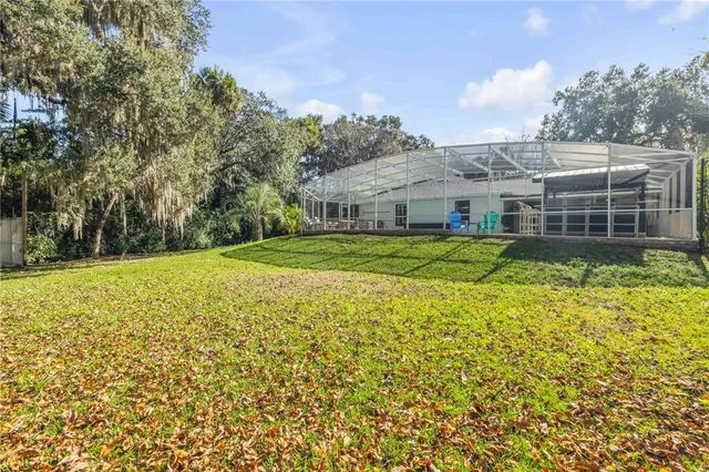 a view of a house with a big yard and large trees