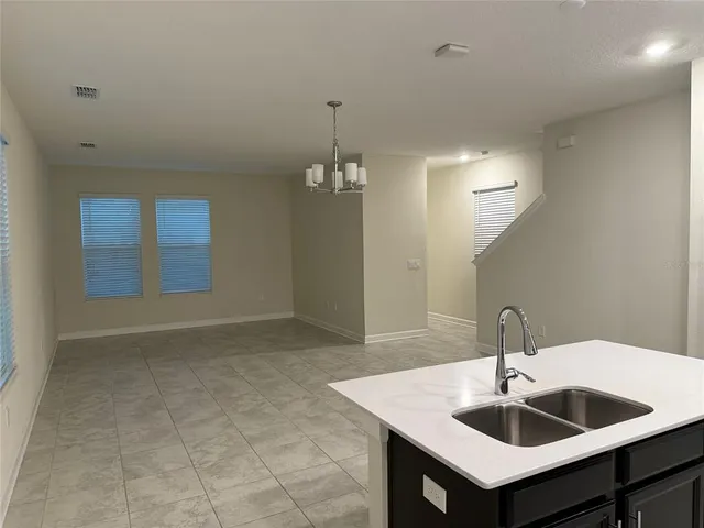 a kitchen with a sink and chandelier