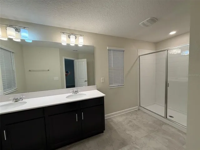 a bathroom with a double vanity sink and a mirror