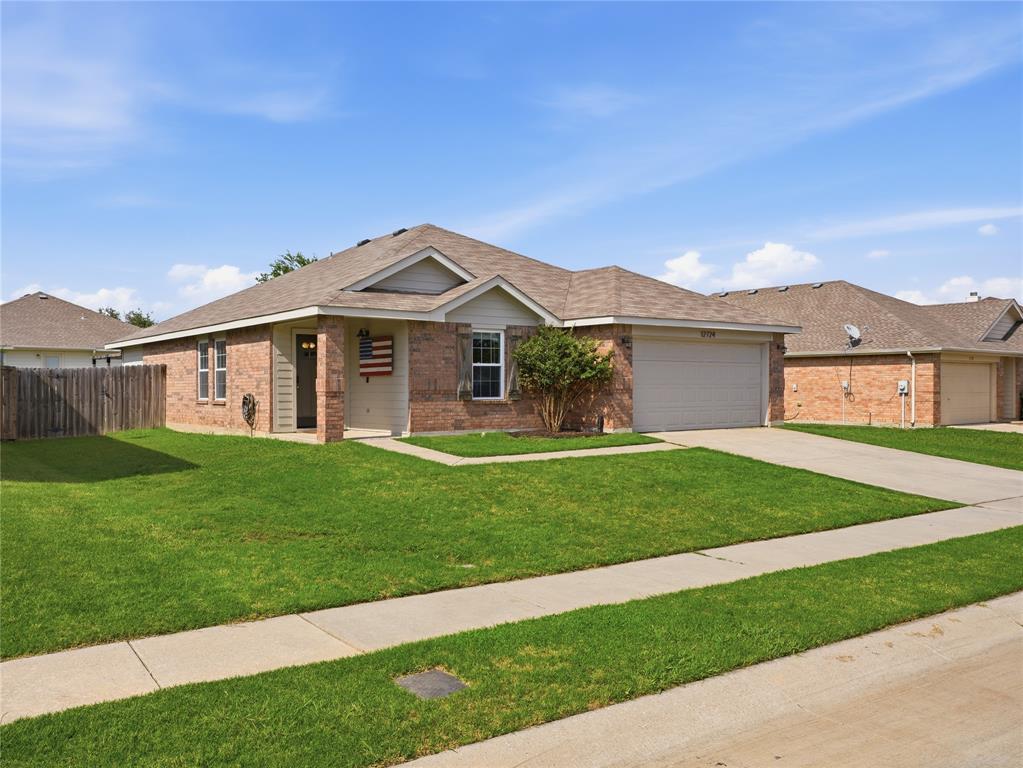 12724 Carpenter Lane Rhome, TX 76078 - Photo 2 of 37 Brick facade home featuring an attached two-car garage, front walkway, and a landscaped lawn