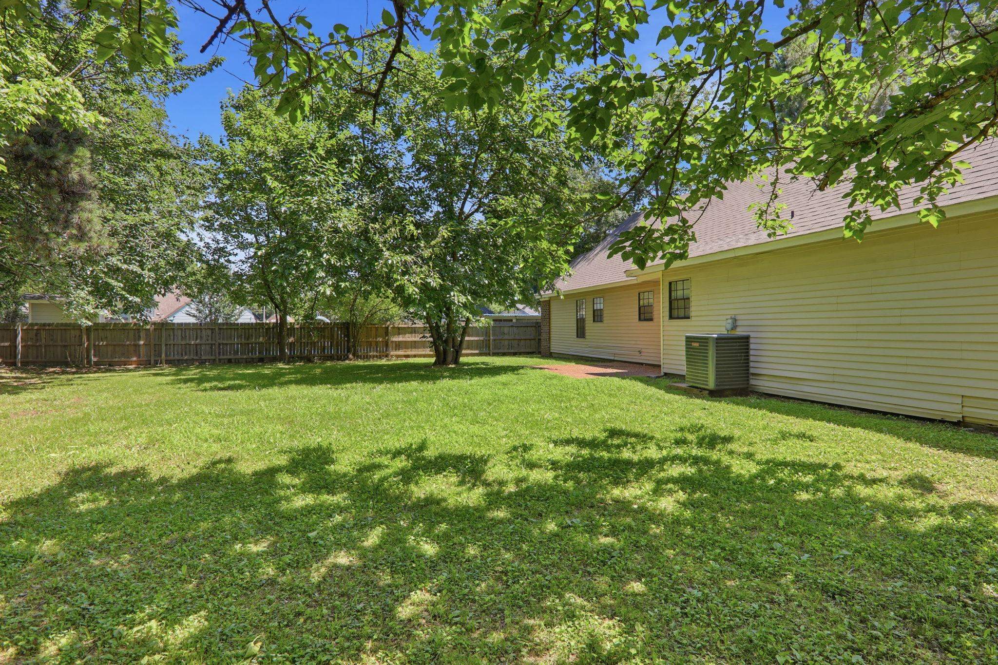 3113 Raleigh Ridge Cove Memphis, TN 38128 - Photo 36 of 38 Spacious backyard featuring a lush lawn, mature trees, and a full privacy fence