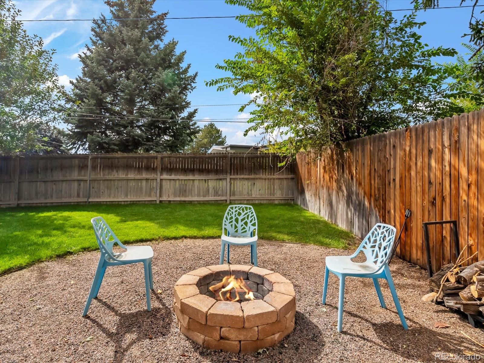 4963 North Harlan Street Wheat Ridge, CO 80033 - Photo 37 of 42 a view of a backyard with table and chairs potted plants and wooden fence