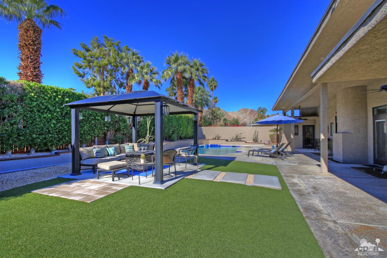 71471 Halgar Road Rancho Mirage, CA 92270 - Photo 45 of 49 a view of a patio with a table and chairs under an umbrella