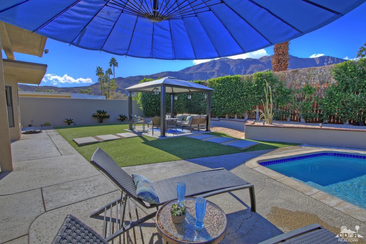 71471 Halgar Road Rancho Mirage, CA 92270 - Photo 7 of 49 a patio with a table and chairs under an umbrella