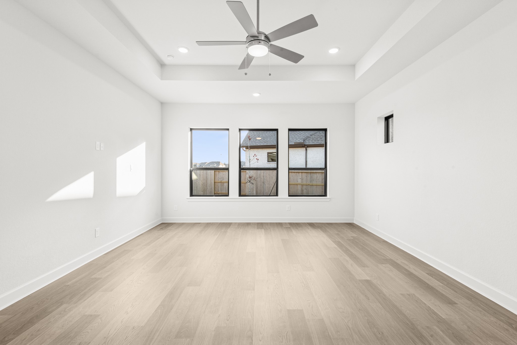 15748 Terracotta Terrace Lane Conroe, TX 77302 - Photo 37 of 50 an empty room with wooden floor chandelier fan and windows