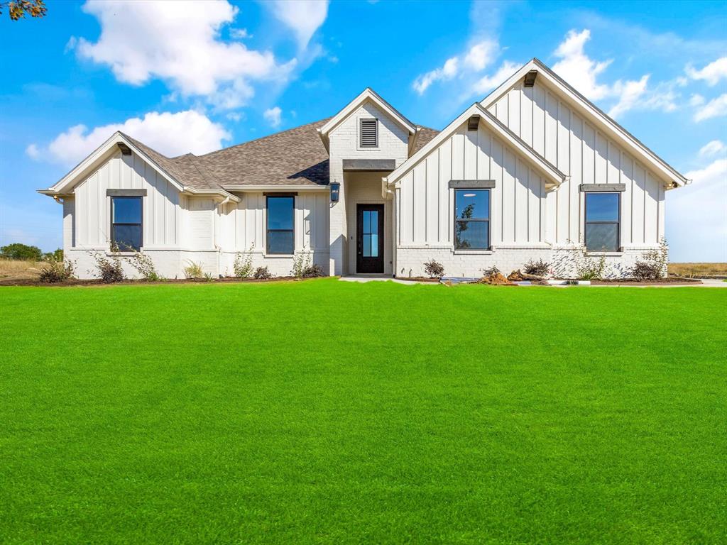 a front view of a house with a garden and yard