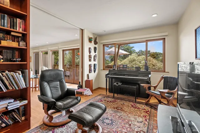 a living room with furniture a bookshelf and a large window