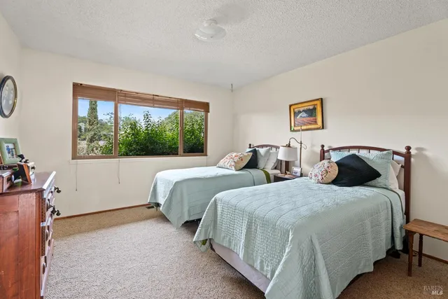 a bedroom with two beds and a large window