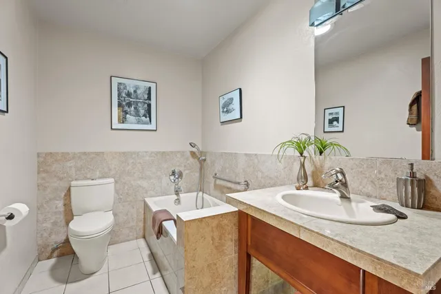 a bathroom with a granite countertop sink and a toilet