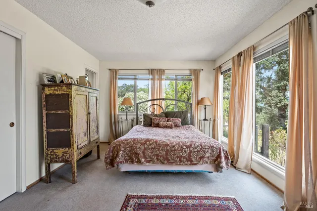 a bedroom with a bed and large window