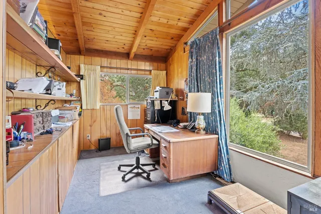 a view of a workspace with furniture and a window