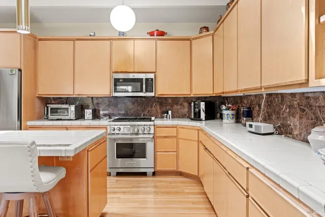 a kitchen with stainless steel appliances granite countertop a sink a stove and a microwave