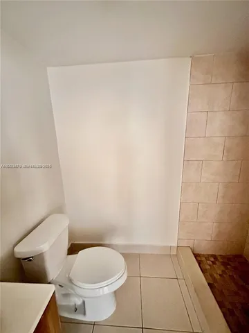 a white toilet sitting next to a white wall