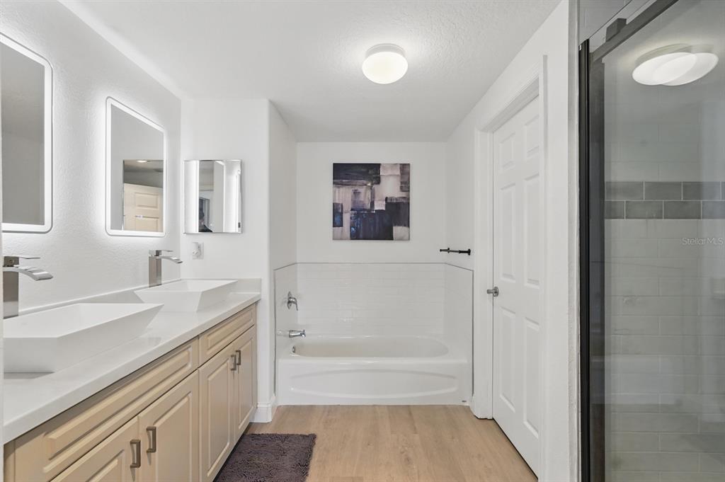 80 Surfview Drive, Unit 511 Palm Coast, FL 32137 - Photo 14 of 25 a bathroom with a tub sink and mirror