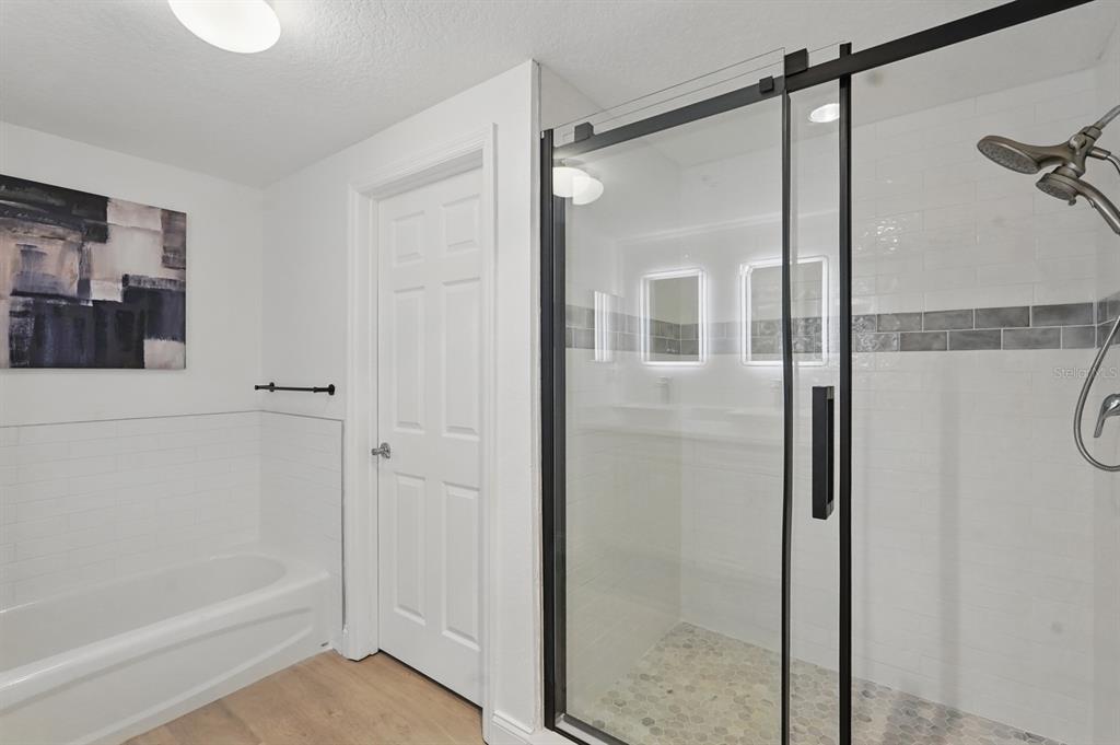 80 Surfview Drive, Unit 511 Palm Coast, FL 32137 - Photo 15 of 25 a bathroom with a glass shower door and a glass door
