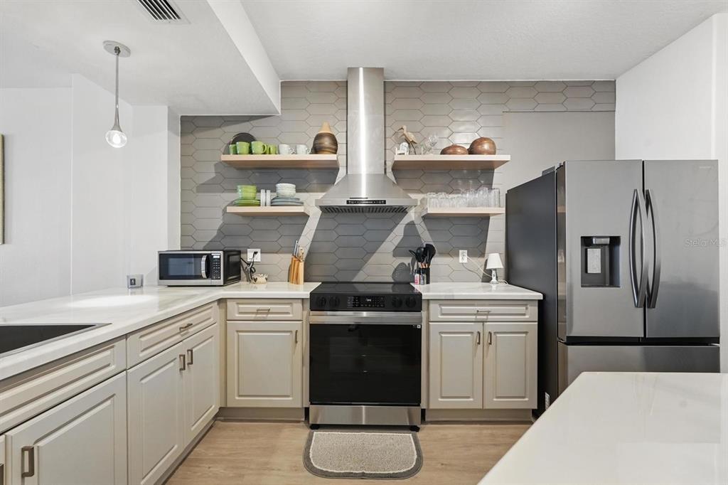 80 Surfview Drive, Unit 511 Palm Coast, FL 32137 - Photo 4 of 25 a kitchen with a stove cabinets and refrigerator