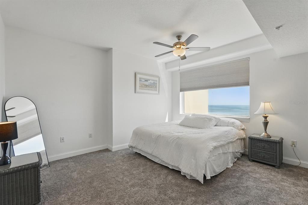 80 Surfview Drive, Unit 511 Palm Coast, FL 32137 - Photo 10 of 25 a bedroom with a bed a chandelier and a window