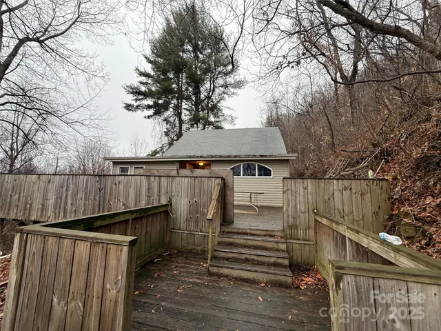 a view of a wooden house with a large tree