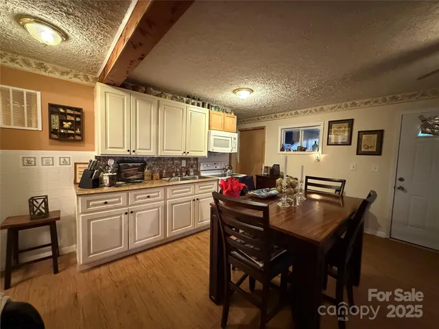 a kitchen with a dining table chairs and cabinets