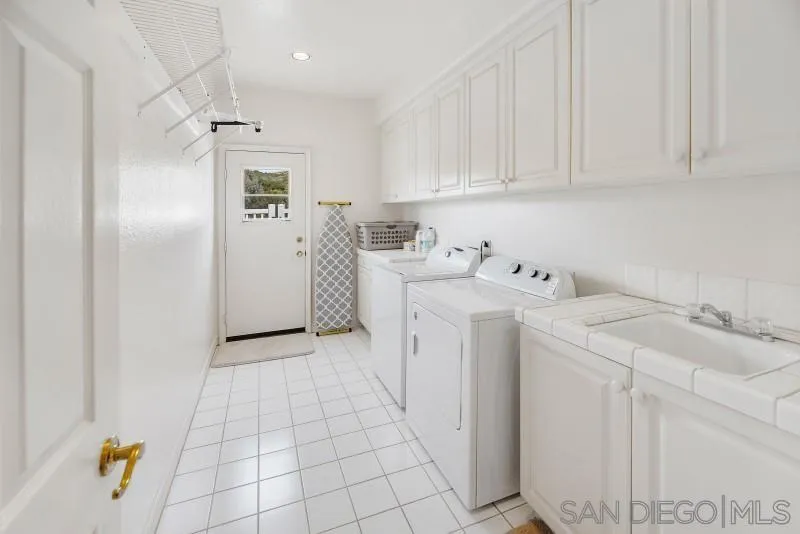 14370 Harvest Crescent Poway, CA 92064 - Photo 36 of 56 a utility room with cabinets washer and dryer