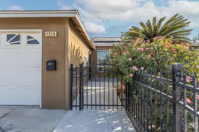 a view of a house with a small yard and potted plants