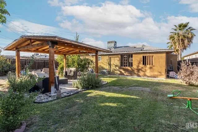 a view of a house with backyard sitting area and garden