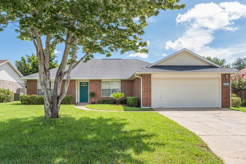 1969 Jessica Way Navarre, FL 32566 - Photo 1 of 17 a front view of a house with a yard and garage