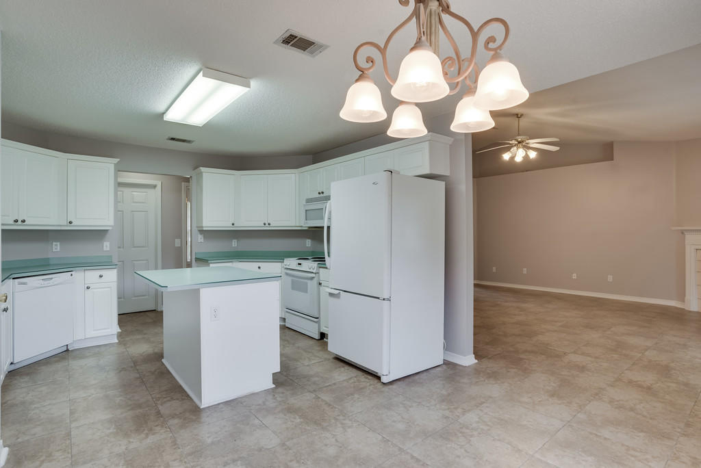 1969 Jessica Way Navarre, FL 32566 - Photo 7 of 17 a kitchen that has a lot of white cabinets and stainless steel appliances